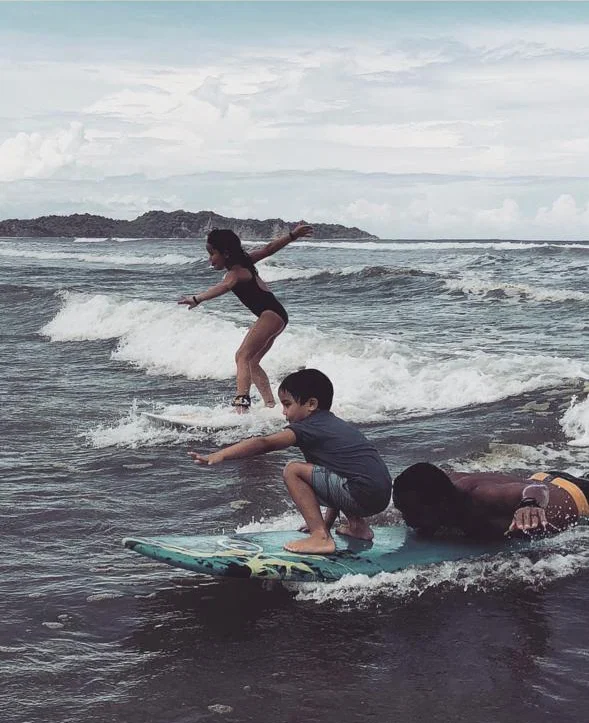 Family surfing together at Playa Guiones, Nosara